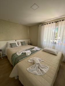 格拉玛多Ipê Amarelo Cama e Café的卧室内的两张床,配有毛巾