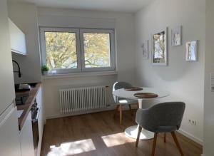 巴登-巴登Eckberg Apartment near City Centre & Nature的厨房配有桌子和两把椅子,设有窗户。