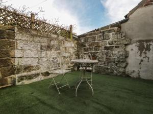 惠特比Rose Cottage的一个带石墙的庭院里的桌椅