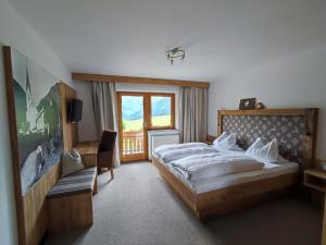 贝旺豪斯艾皮纳酒店的一间卧室设有一张大床和一个窗户。