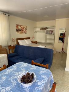 格拉玛多Ipê Amarelo Cama e Café的客厅配有蓝色的沙发和床。