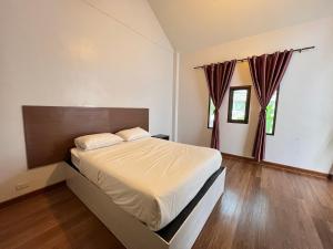 Ban Mae Kham Lang WatThe Green Season Resort的一间卧室设有一张大床,铺有木地板。