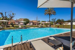 塔维拉Quinta de Santa Margarida - Charm Country House的一个带遮阳伞和椅子的游泳池