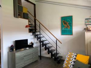 莱特鲁瓦西莱Studioloc'Martinique的一间带楼梯和电视的客厅
