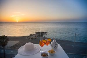 卡普多兰多Seaside Hotel的沙滩上一张桌子,上面放着玻璃杯和碗