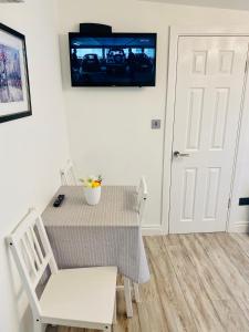 都柏林Lodge Apartment的餐桌和椅子,墙上配有电视