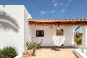伊维萨镇CAN TEO - Holiday Villa in Ibiza的白色房子内带吊床的庭院