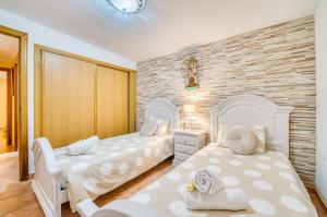 印加Ideal Property Mallorca - Can Caragol Inca的一间卧室设有两张床和砖墙