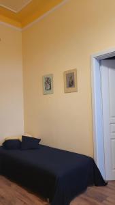 玛丽亚温泉Apartmán U kolonády的卧室配有一张床,墙上挂有两张照片