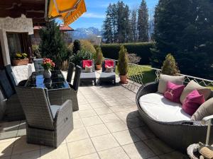 巴特维塞Alpen Suite Tegernsee - große Sonnenterasse und idyllischer Garten的天井配有沙发和桌椅