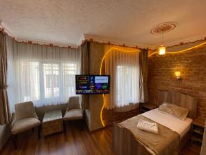 伊斯坦布尔GOLDEN ARROW OLD CİTY HOTEL的卧室配有一张床,墙上配有电视。