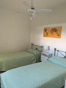 卡塔马卡Apart Ocampo Catamarca的一间卧室配有两张床和吊扇