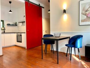 皮尔纳Hip & Minimalist - Stadt Apartments am Malerweg的厨房里设有红色的门,配有桌椅