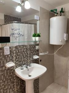 卡塔马卡Apart Ocampo Catamarca的浴室配有白色水槽和热水器