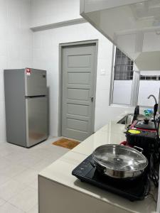 实兆远Manjung Vermogen Stay-Wi-Fi+KTV(Near Aeon)的厨房配有炉灶和柜台上的平底锅