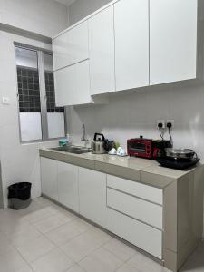 实兆远Manjung Vermogen Stay-Wi-Fi+KTV(Near Aeon)的厨房配有白色橱柜和台面