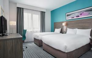 南安普敦Leonardo Hotel Southampton的酒店客房设有两张床和一台平面电视。