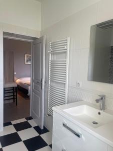 Saint-Barthélémy-dʼAgenaisDOMAINE DES PEYRIES - Chambres et table d'hôtes的一间带水槽的浴室和一间带床的房间