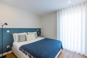 波尔图Pestana Apartments - Premium的一间卧室配有一张带蓝色毯子的大床