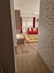 布拉索夫Casă și curte confortabilă的客厅设有红色沙发和砖墙