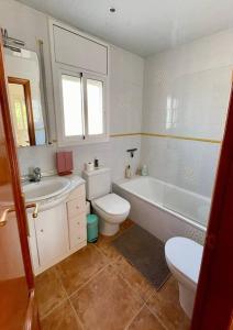 卡拉费尔Tu pequeño paraíso的浴室配有卫生间、浴缸和水槽。