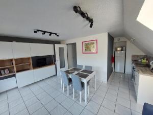 勒蒙多尔Appartement T2 45m² avec terrasse - 4/6 personnes的厨房以及带桌椅的用餐室。