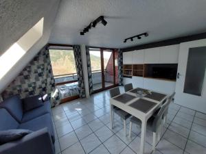 勒蒙多尔Appartement T2 45m² avec terrasse - 4/6 personnes的客厅配有桌子和蓝色沙发