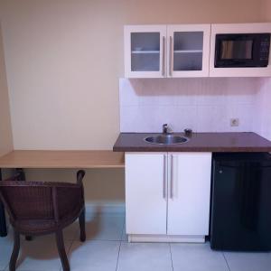 帕拉马里博101 Suites的一间带水槽和微波炉的小厨房