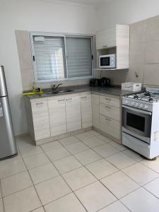卡塔马卡Apart Ocampo Catamarca II的厨房配有白色橱柜和炉灶。