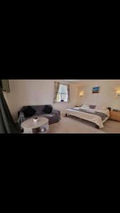 佩恩顿3 Bedroom Bungalow with great Sea Views, Private Hot Tub & Gardens的一间带两张床和一张沙发的客厅