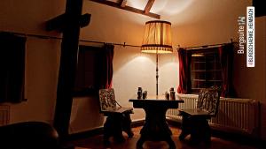 海姆巴赫Burg Zimmer auf ca. 70 m²的一间设有桌子、两把椅子和一盏灯的房间
