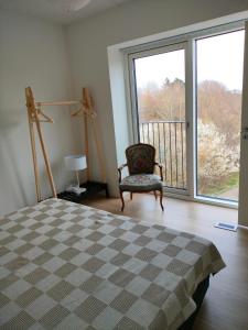 RødovreNy bolig i grønne omgivelser.的一间卧室配有一张床、一把椅子和一个大窗户