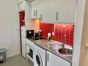 瓦伦西亚Acogedor Apartamento的一间带水槽和红色瓷砖的小厨房