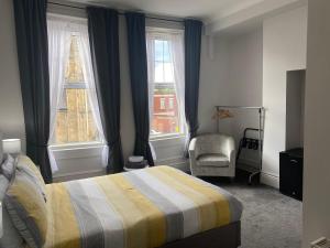 南希尔兹阿索尔宾馆的一间卧室配有一张床和一把椅子,还有两个窗户