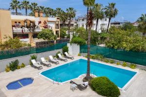 凯麦尔Perlo Hotel Kemer的享有带躺椅和棕榈树的游泳池的顶部景致