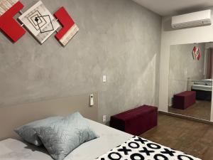 索罗卡巴Flat Aconchegante的一间卧室配有一张床和镜子