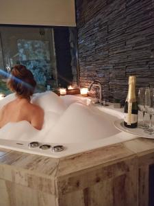 拉博尔萨Aluleta Suites的浴缸里的女士,带一瓶香槟