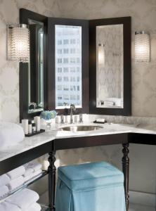 波特兰波特兰奈士豪华精选酒店的浴室设有水槽、镜子和蓝色凳子。