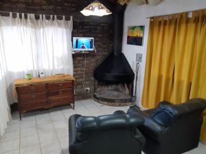 波特雷里约斯Lo de Quebu Cabaña en la Montaña的客厅设有壁炉、沙发和电视