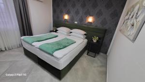 耶泽尔采Plitvice Inn的一间卧室配有一张带绿床单和枕头的床。