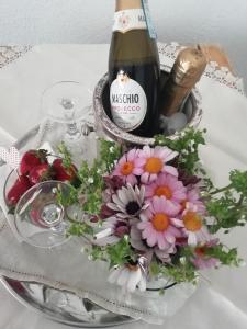 维克艾库塞La Fusarella Villa Santoro的桌子上放着一瓶葡萄酒和鲜花