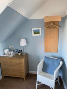 克雷尔Honeypot Guest House的蓝色客房,配有椅子和梳妆台
