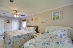 Pass ChristianCharming Family Cottage Near Pass Christian Beach!的一间卧室配有两张床和吊扇