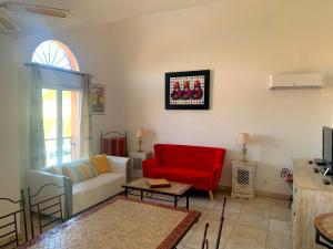 贝济耶Terrasse du golf的带沙发和红色椅子的客厅