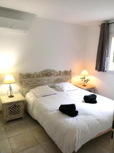 贝济耶Terrasse du golf的一间卧室配有一张大床,上面有两条黑色毛巾