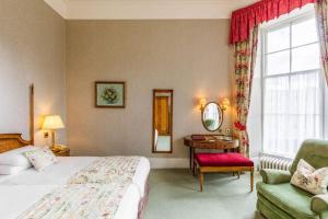 盖特豪斯厄夫弗利特Cally Palace Hotel & Golf Course的酒店的客房 - 带一张床、椅子和窗户