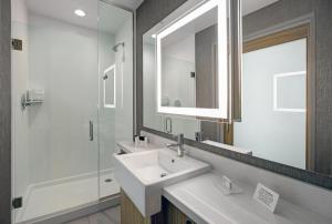 富兰克林SpringHill Suites by Marriott Franklin Cool Springs的一间带水槽、淋浴和镜子的浴室