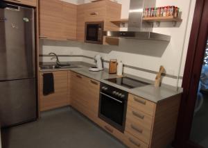 卡萨雷斯Appart cosy Golf Garden Casares的厨房配有木制橱柜和炉灶烤箱。