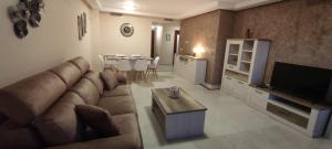 卡萨雷斯Appart cosy Golf Garden Casares的带沙发、电视和桌子的客厅