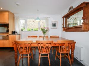 纽基Bro Tref Cottage的厨房配有木桌和椅子